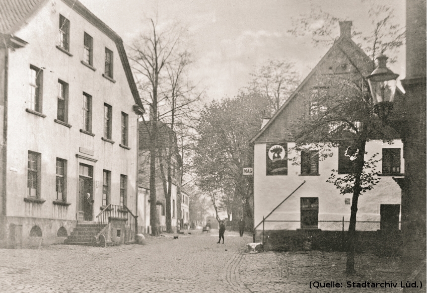 Foto: Zwei alte Häser, dazwischen eine Durchfahrt.