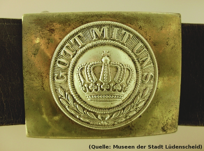 Foto: Ein Gürtel mit einem Koppelschloß: Prägung: Eine Krone in der Mitte, Schriftzug oben im Halbkreis: 'Gott mit uns',  Unten im Halbkreis einb Lorbeerkranz.