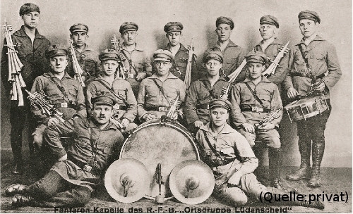 Foto: Eine Musikkapelle. Schriftzug am unteren Rand des Fotos: 'Fanfarenkapelle des R.-F.-B. "Ortsgruppe Lüdenscheid"'